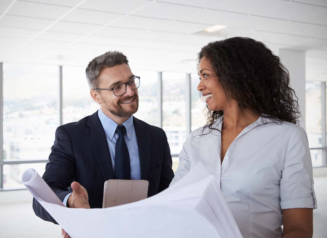 Real Estate Developer Insurance - Real Estate Developers Meeting in an Empty Office of a Tall Corporate Building to Look Over Development Plans